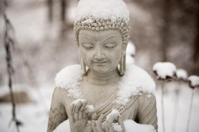 Eine Buddha-Statue im Schnee.
