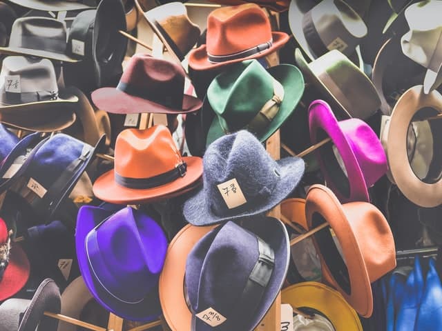 Viele verschiedene farbige Hüte auf Hutständern